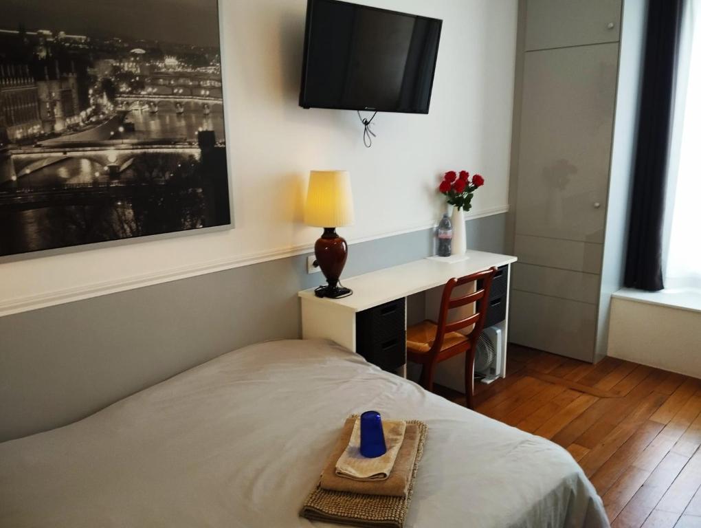 une chambre avec un lit, un bureau et une télévision dans l'établissement Belle chambre avec sanitaires privatifs, à Paris