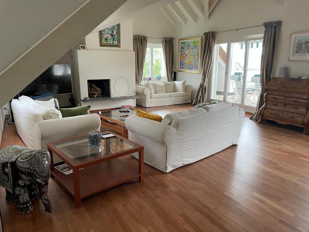 una sala de estar con muebles blancos y una escalera. en Spacious and stylish Apartment in Zurich en Zúrich