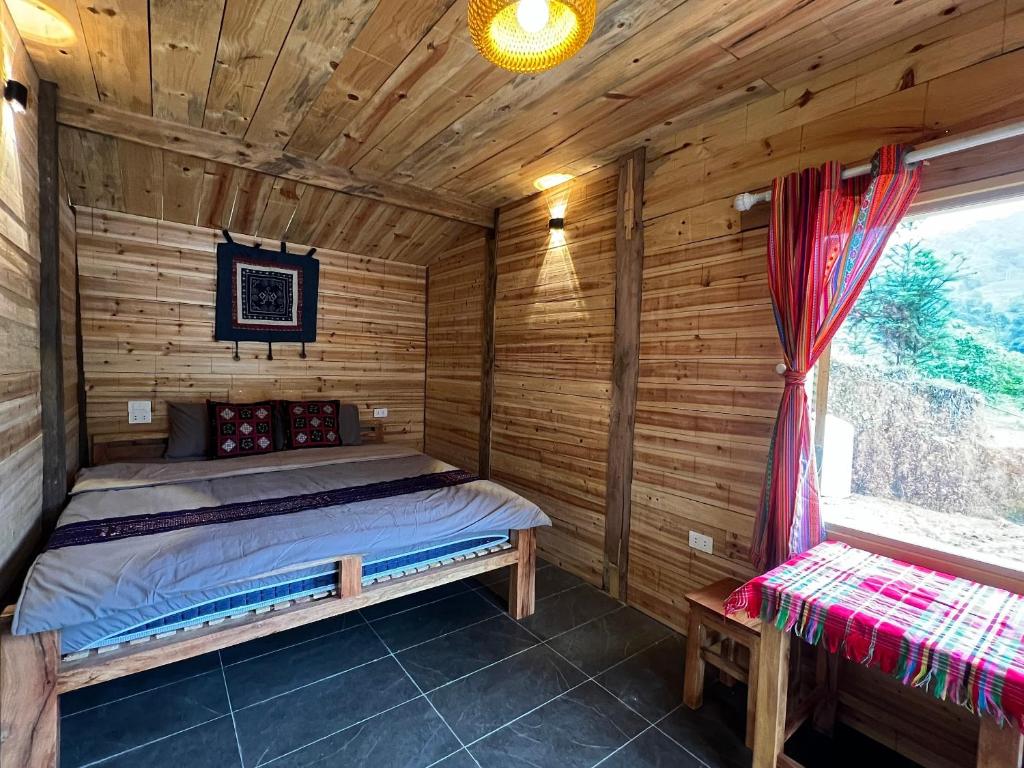 1 dormitorio con 1 cama en una cabaña de madera en Nậm Lỳ Retreat- Breakfast included, en Ha Giang