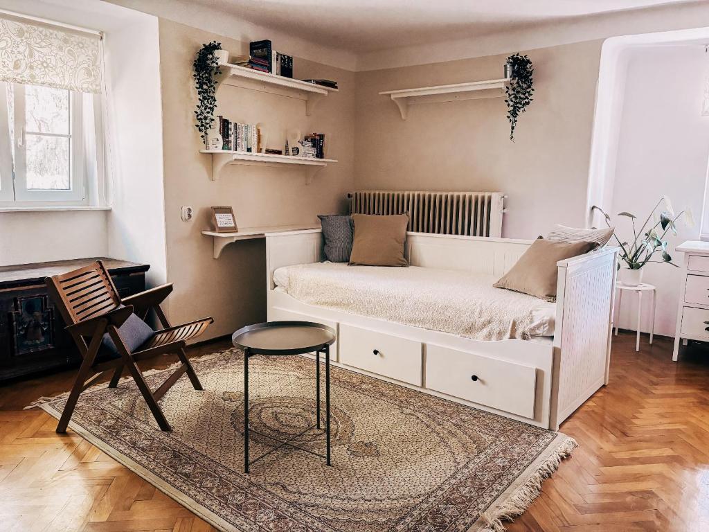 - une chambre avec un lit blanc et une chaise dans l'établissement Vila Del Linz, à Ljubljana