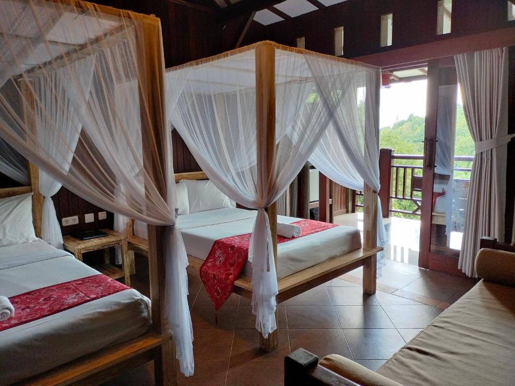 sypialnia z 2 łóżkami i moskitierami w obiekcie BINTANG MUNDUK w mieście Munduk