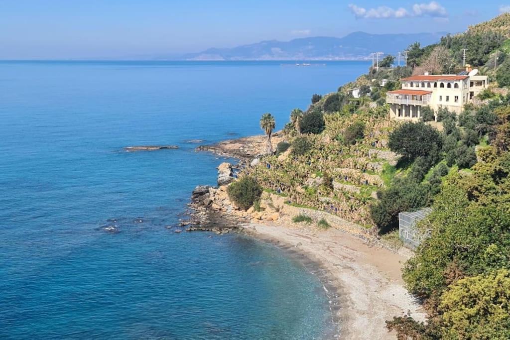 ein Haus auf einem Hügel neben dem Meer in der Unterkunft Uğrak Home in Işıklı