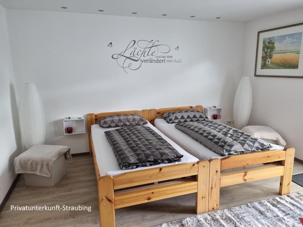 a bedroom with two beds and a sign on the wall at Privatunterkunft Straubing in Straubing
