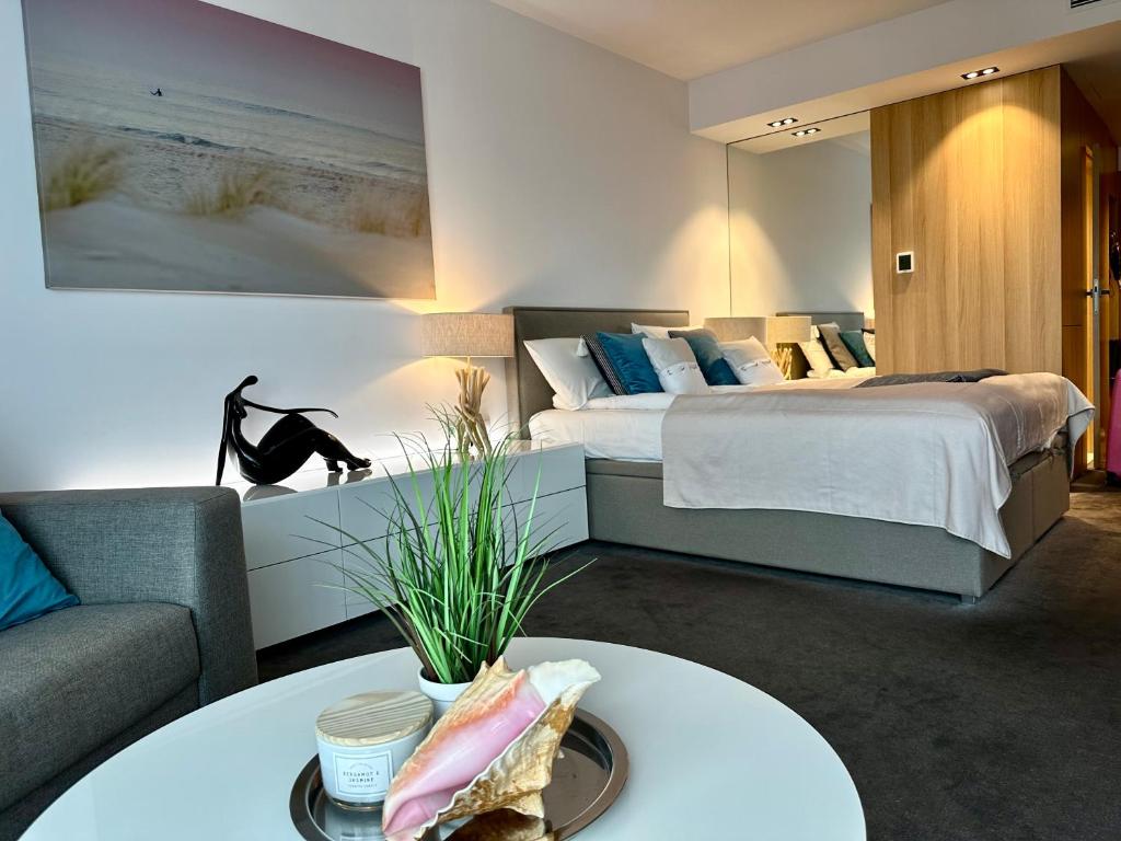 a bedroom with a bed and a couch and a table at Seaside Luxury Apartament in Kołobrzeg