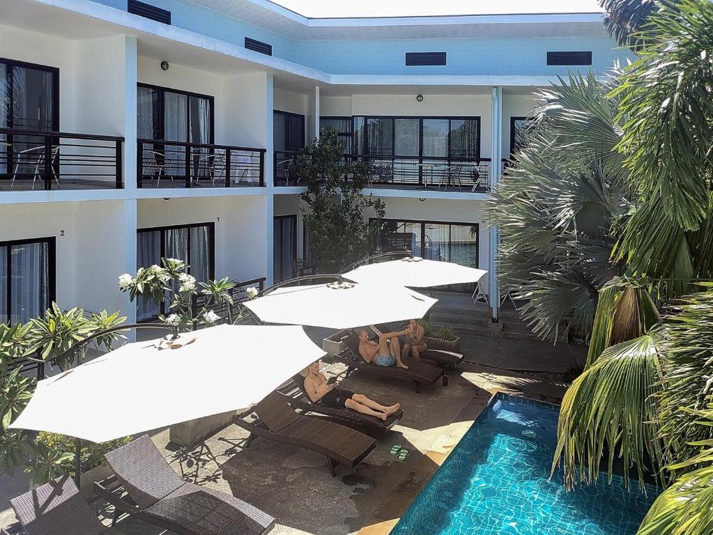 an apartment building with umbrellas and a swimming pool at Villa LunaSole Samui in Koh Samui 