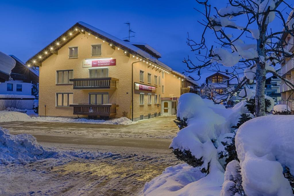 a building with lights on it in the snow at KAISERS das kleine Stadthotel in Sonthofen