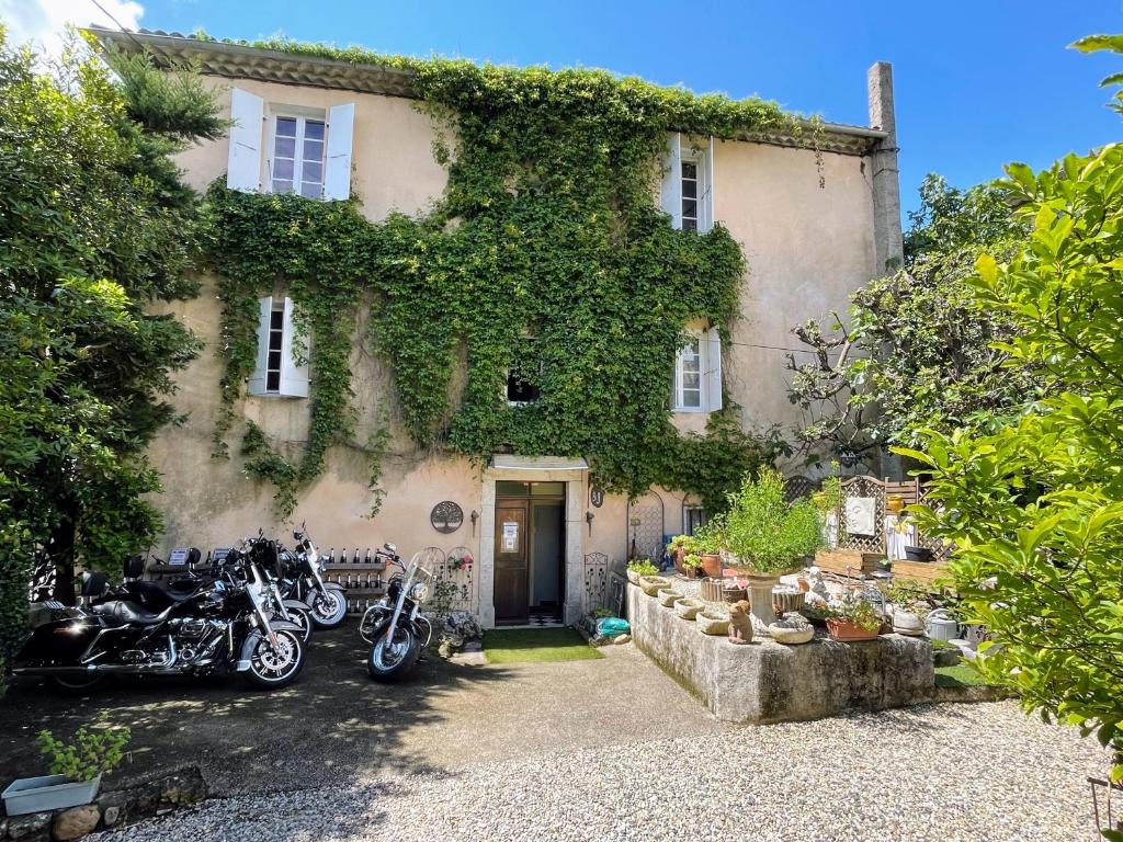 une maison avec des motos garées devant elle dans l'établissement Maison du Manoir, à Vallon-Pont-dʼArc