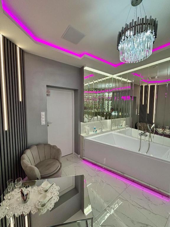 a large bathroom with a tub and a chair at Apartament "Prezydencki Deluxe" Centrum z dużą wanną dla Dwojga in Gniezno
