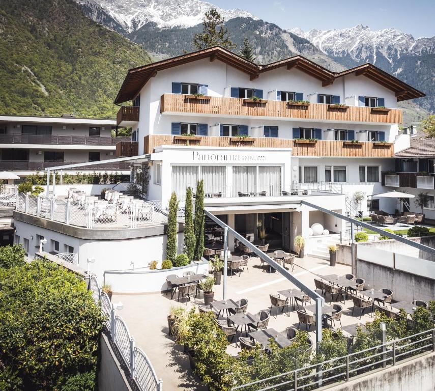 un hôtel dans les montagnes avec des tables et des chaises dans l'établissement Hotel Panorama, à Rablà