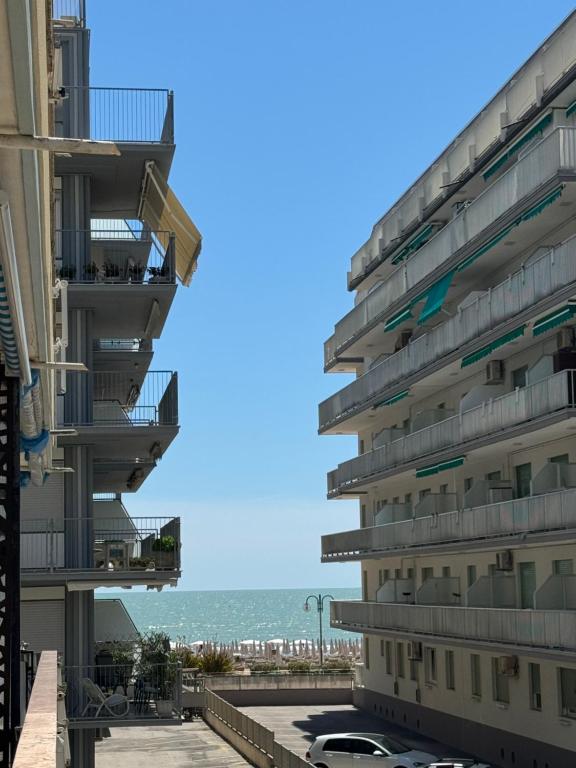 um edifício com varandas e o oceano ao fundo em Appartamento luminoso vista mare em Lido di Jesolo