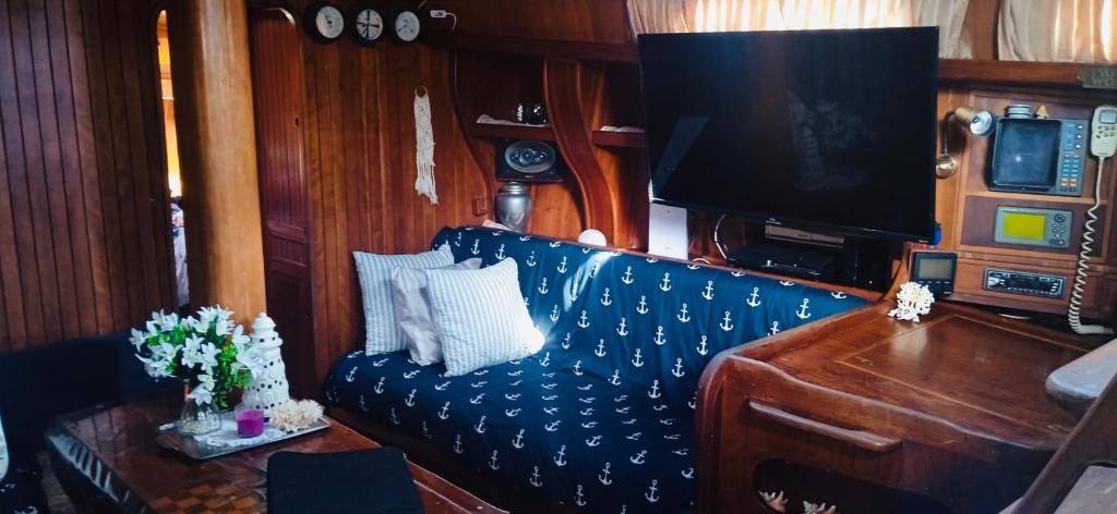 ein Wohnzimmer mit einem blauen Sofa und einem TV in der Unterkunft Sail boat in Bocas del Toro in Carenero