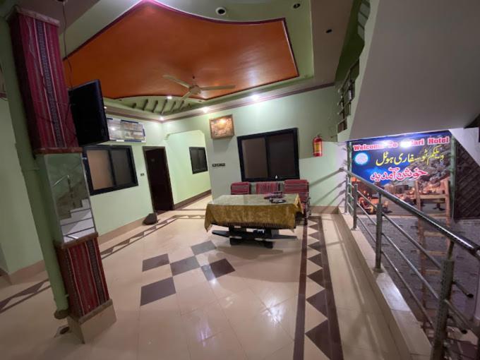 Safari Hotel في Dera Ghāzi Khān: غرفة معيشة مع أريكة وطاولة في غرفة