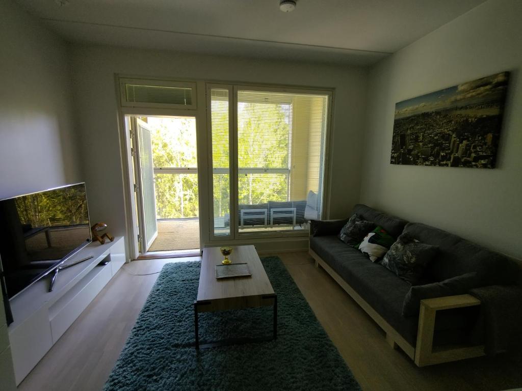 ein Wohnzimmer mit einem Sofa und einem Couchtisch in der Unterkunft Modern compact apartment 25 minutes from Helsinki in Espoo