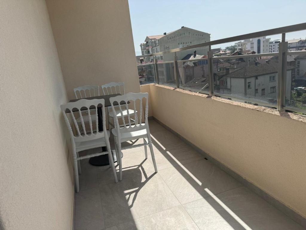 2 Stühle auf einem Balkon mit Stadtblick in der Unterkunft Hotel Palace Struga in Struga