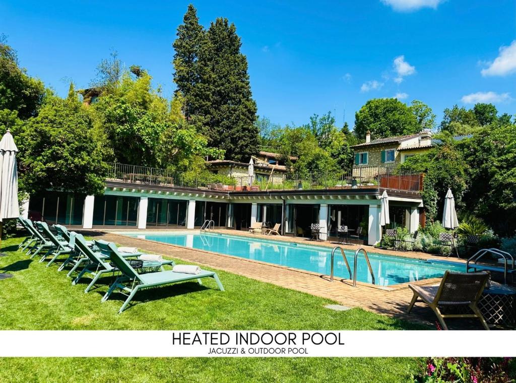 Relais Villa dei Gelsi & Spa في فيرونا: منزل به مسبح وكراسي صالة