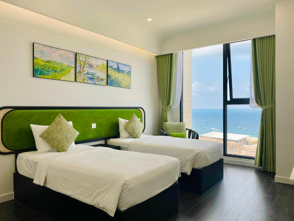 deux lits dans une chambre avec vue sur l'océan dans l'établissement Le Ciel Phu Quoc - Hillside Apartment, à Duong Dong