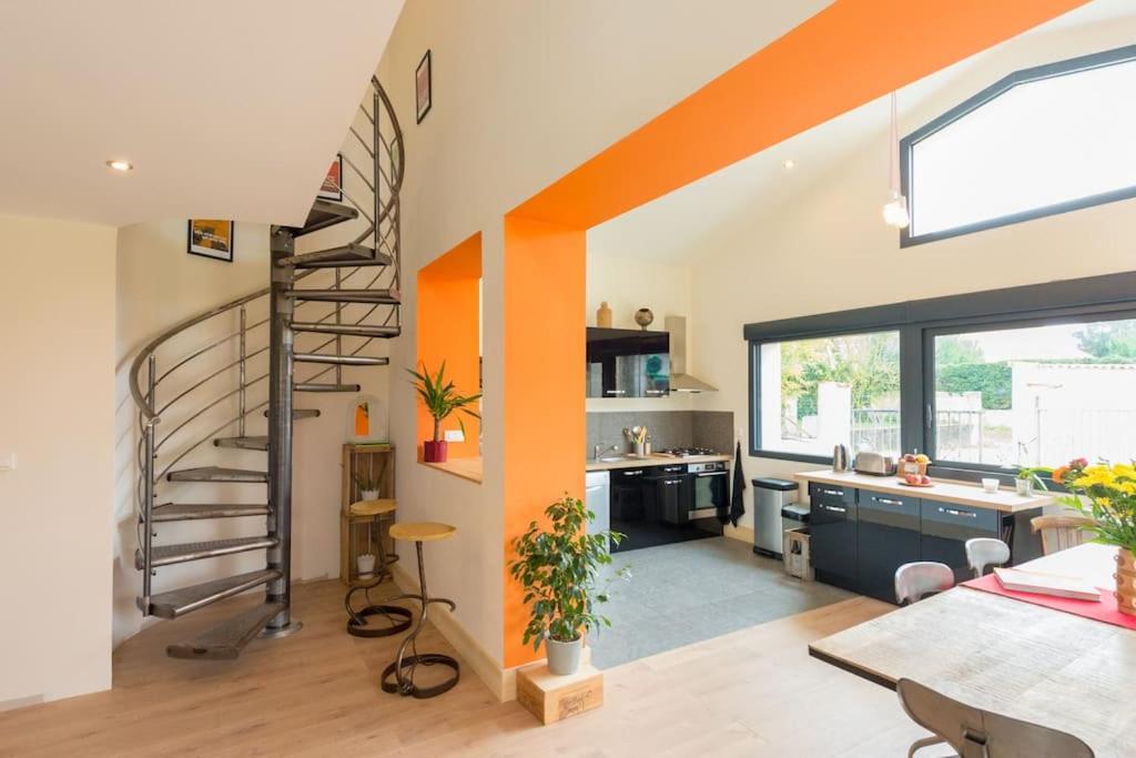 une cuisine avec un escalier en colimaçon dans une pièce dans l'établissement Maison aux portes du marais, à Courçon