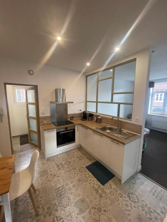 a kitchen with a sink and a stove top oven at Séjourner chez Mina in Lille
