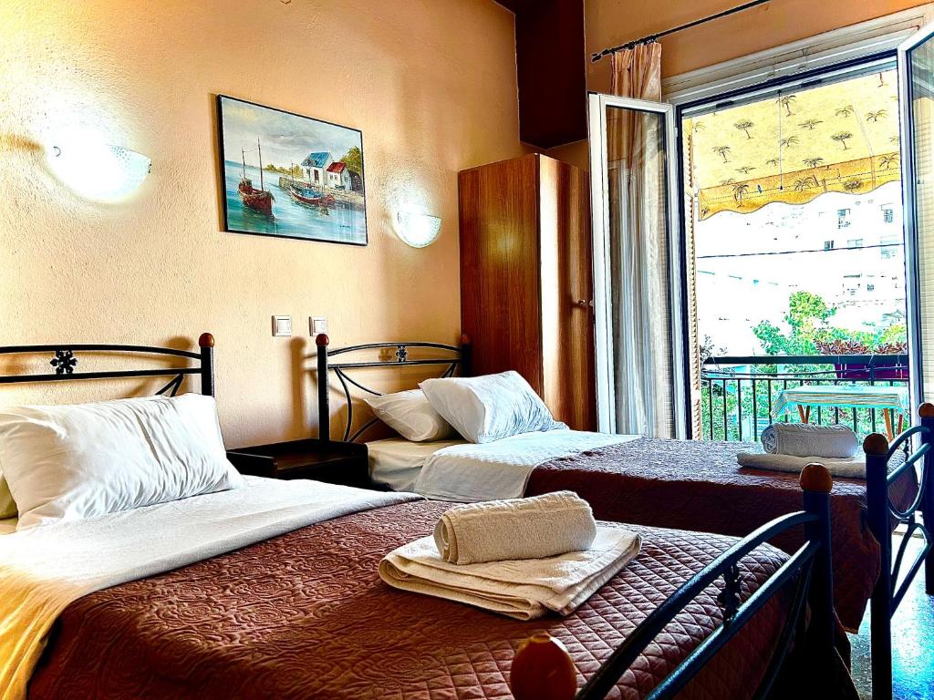 Habitación de hotel con 2 camas y ventana en Retro Rooms, en Loutra Edipsou