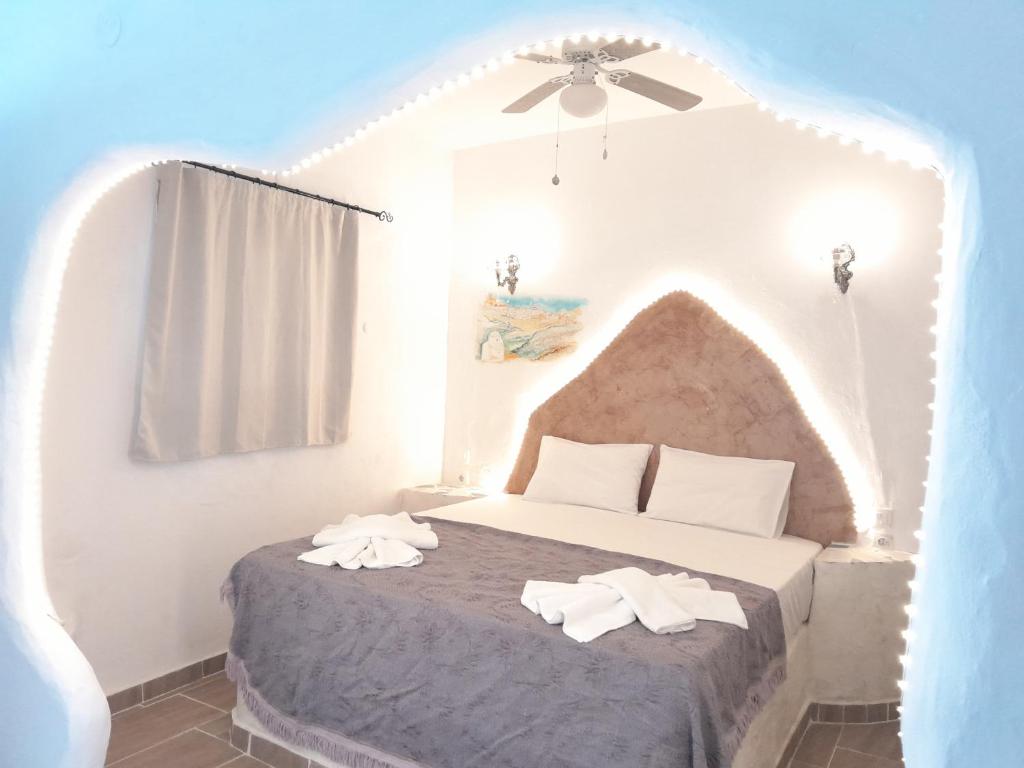 ein Schlafzimmer mit einem Bett mit zwei Handtüchern darauf in der Unterkunft Lavish Sunset Suite Arkasa in Arkasa