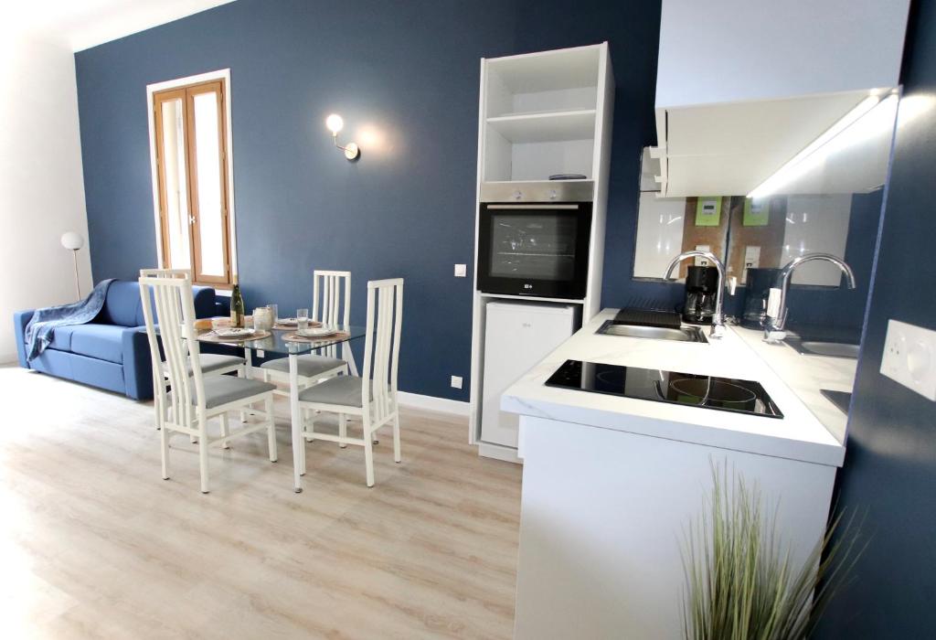 une cuisine et une salle à manger avec une table et des chaises dans l'établissement La Villa Riquet Menton, à Menton