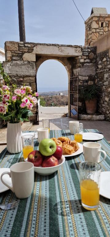 a table with a plate of fruit and pastries on it at Yiannis Village house in Asklipiḯon