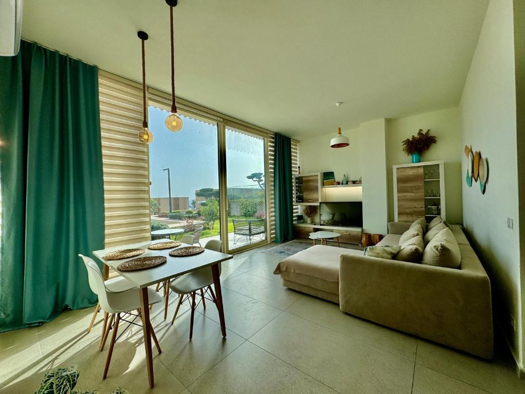 a living room with a couch and a table at Green Coast, Palase 148 in Palasë