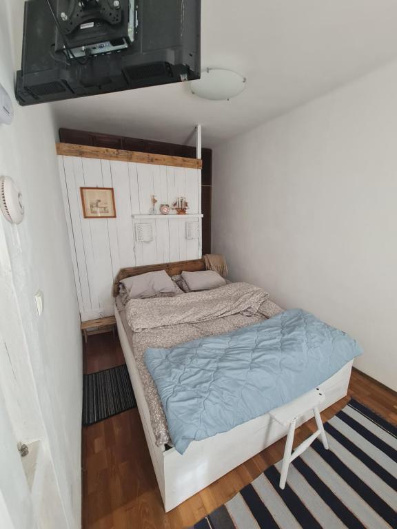 een kleine slaapkamer met een bed in een kamer bij Hangulatos kis lakás a belvároshoz közel in Szeged