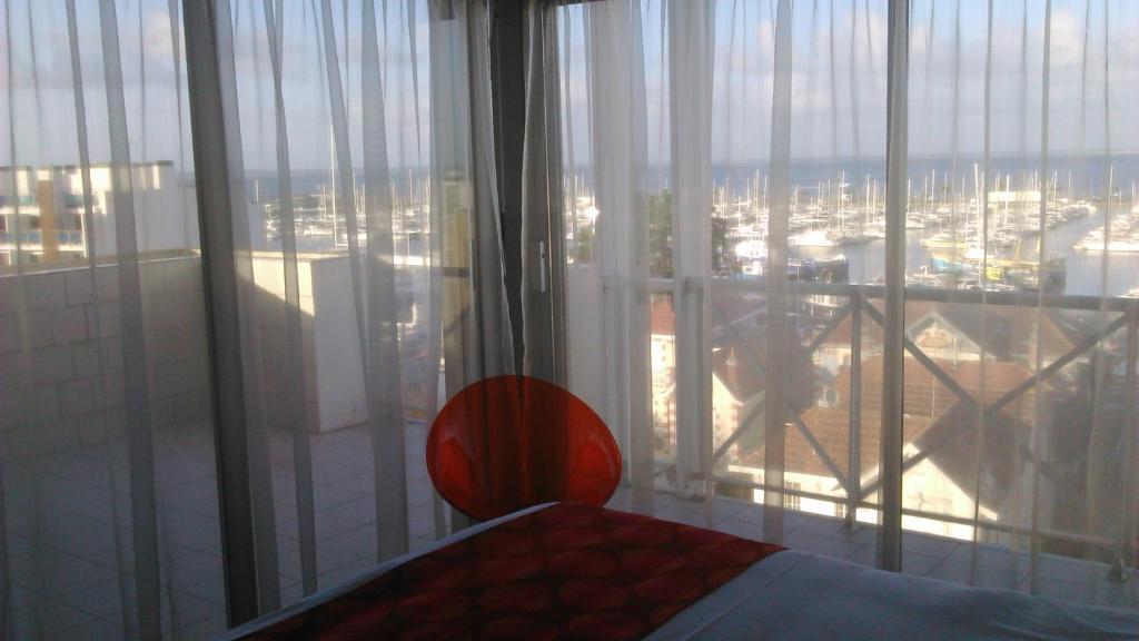 a bedroom with a large window with a view of a city at Hôtel Le Nautic in Arcachon