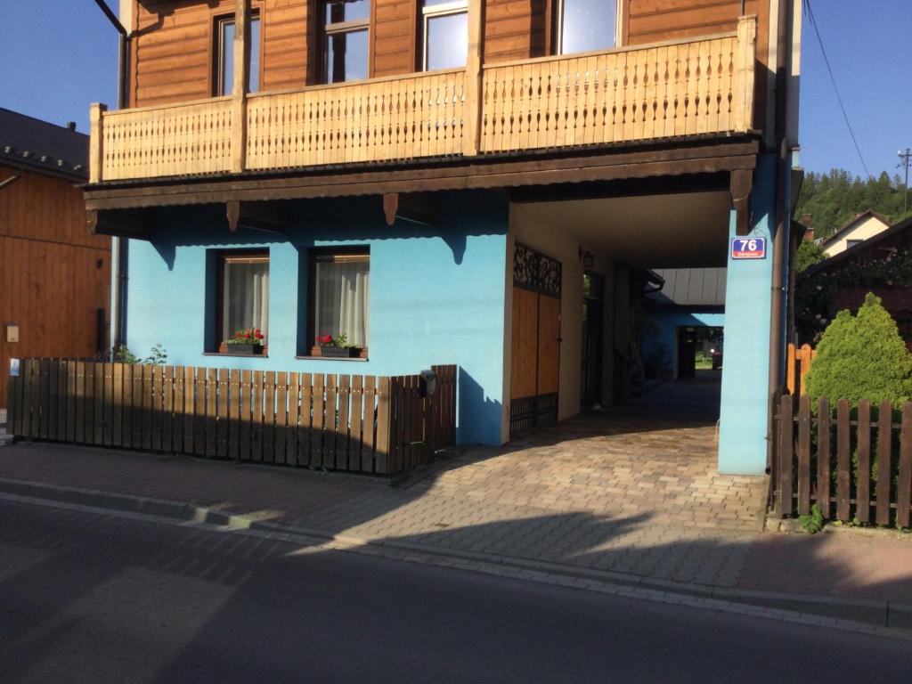 uma casa azul com uma varanda em cima em Willa Trzy Podkowy em Krościenko