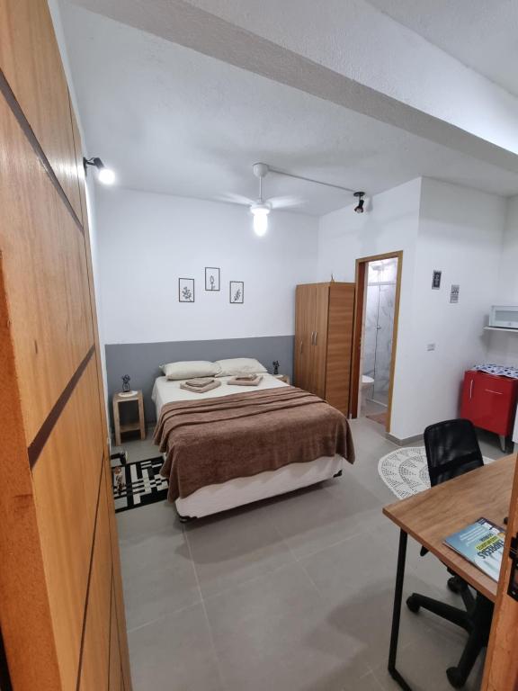 um quarto com uma cama, uma secretária e uma mesa em Studio fantástico em São Paulo