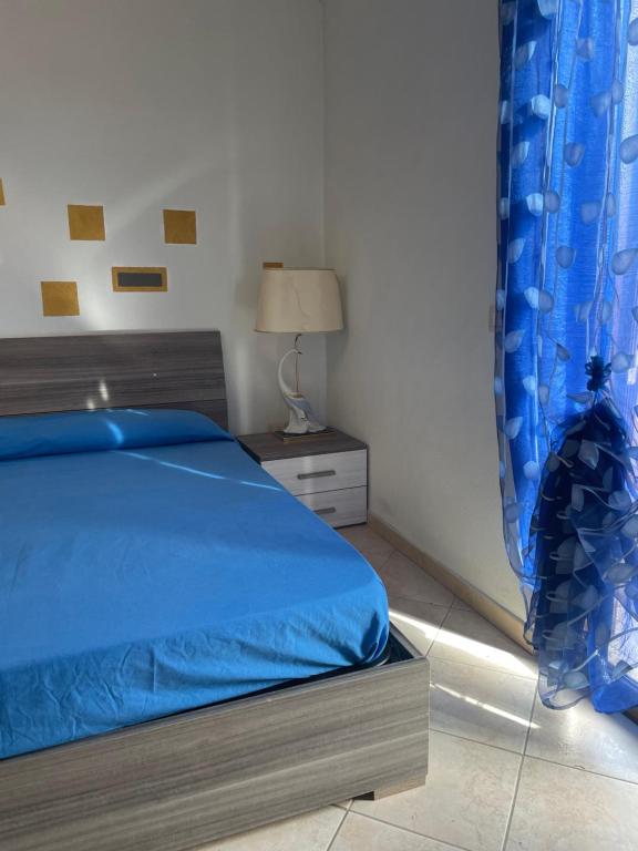 een slaapkamer met een bed met een blauw dekbed bij Villa Silvia in Fontana Liri Inferiore