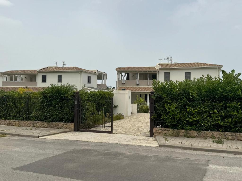 una puerta a una casa con casas en el fondo en Villa Elemiri en Buonfornello