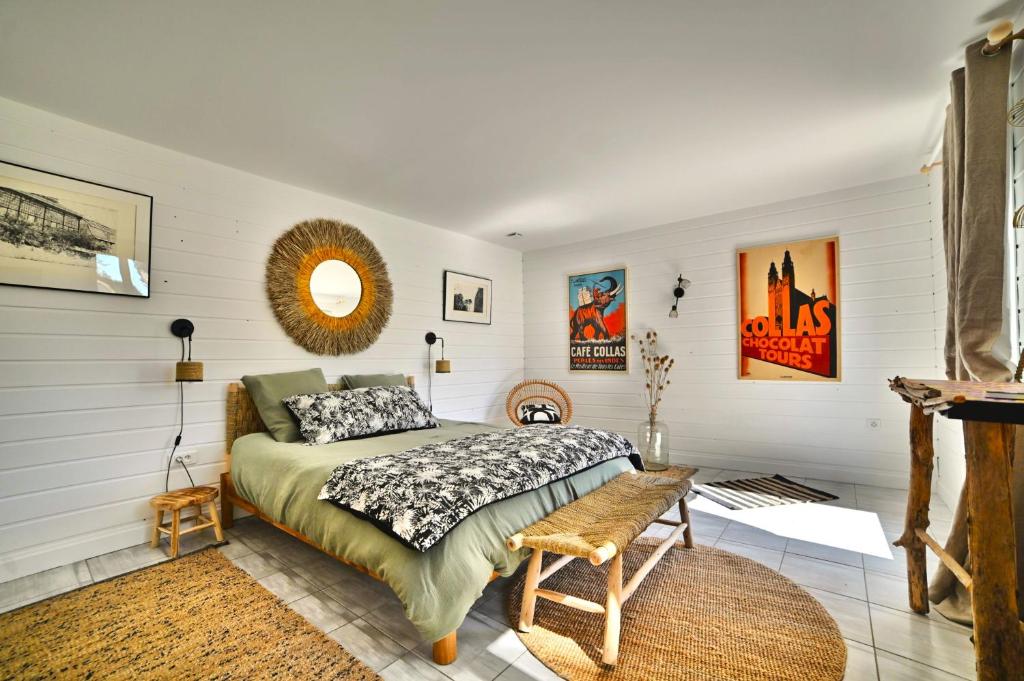 une chambre avec un lit dans une pièce aux murs blancs dans l'établissement Hirondelles et Abeille, à La Tremblade