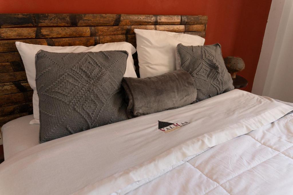 ein weißes Bett mit Kissen und Papier darauf in der Unterkunft ValMas H in Chachapoyas