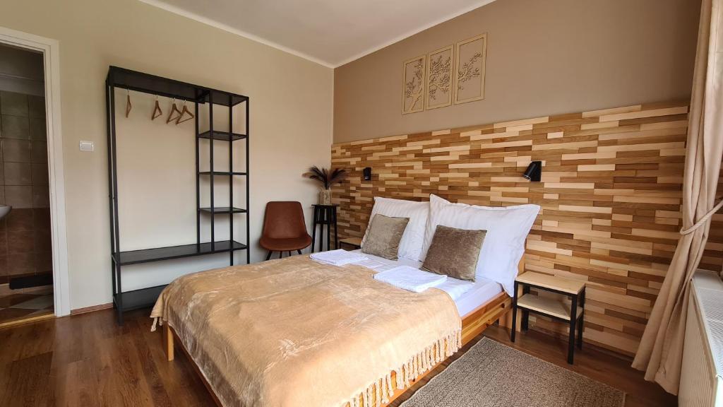 1 dormitorio con 1 cama y pared de madera en Bakonyi Kiscsillag, en Bakonybél