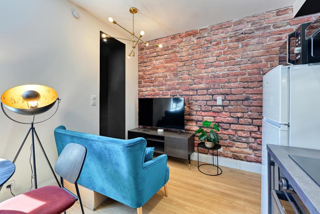 - un salon avec un mur en briques et une chaise bleue dans l'établissement L'urbain, à Arras