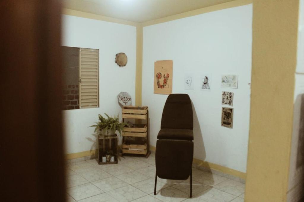 ein Zimmer mit einem schwarzen Stuhl in einem Zimmer in der Unterkunft Casa inteira no maior São João do Brasil! in São José de Ribamar
