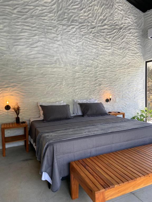 - une chambre avec un lit et un banc en bois dans l'établissement Casa Physis, à Capitólio
