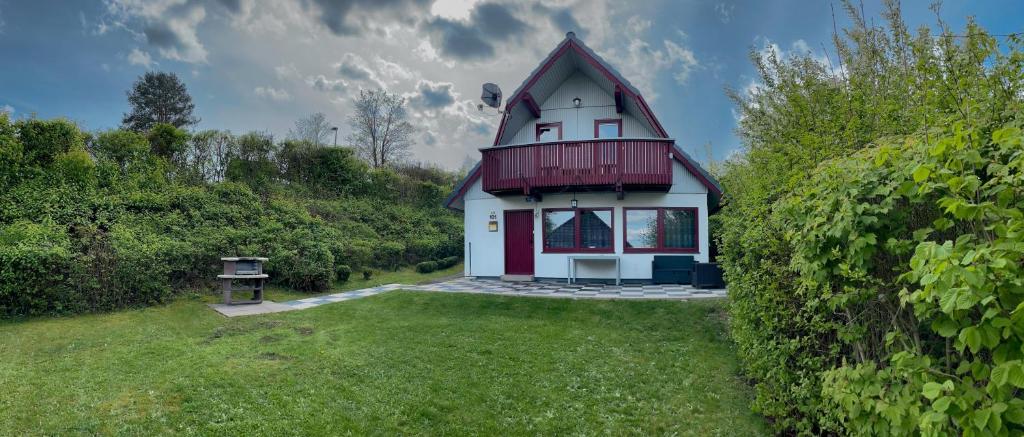 una pequeña casa con techo rojo en un patio en Ferienhaus am See im Bergland, en Kirchheim