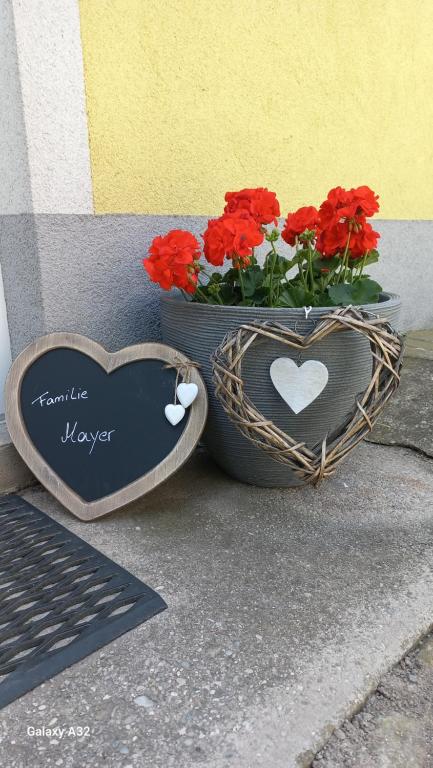un signo cardíaco junto a un jarrón de flores en (W)einHaus am See, en Rust