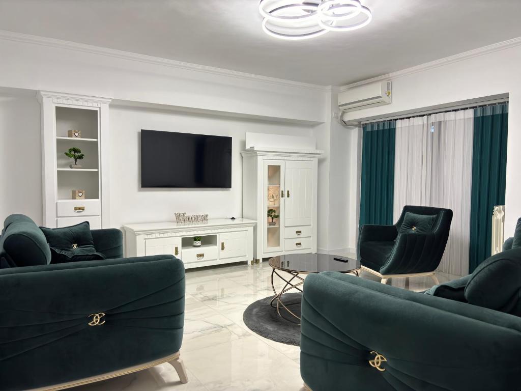 salon z 2 krzesłami i telewizorem w obiekcie Cozy Apartament in Center of Bucharest w Bukareszcie