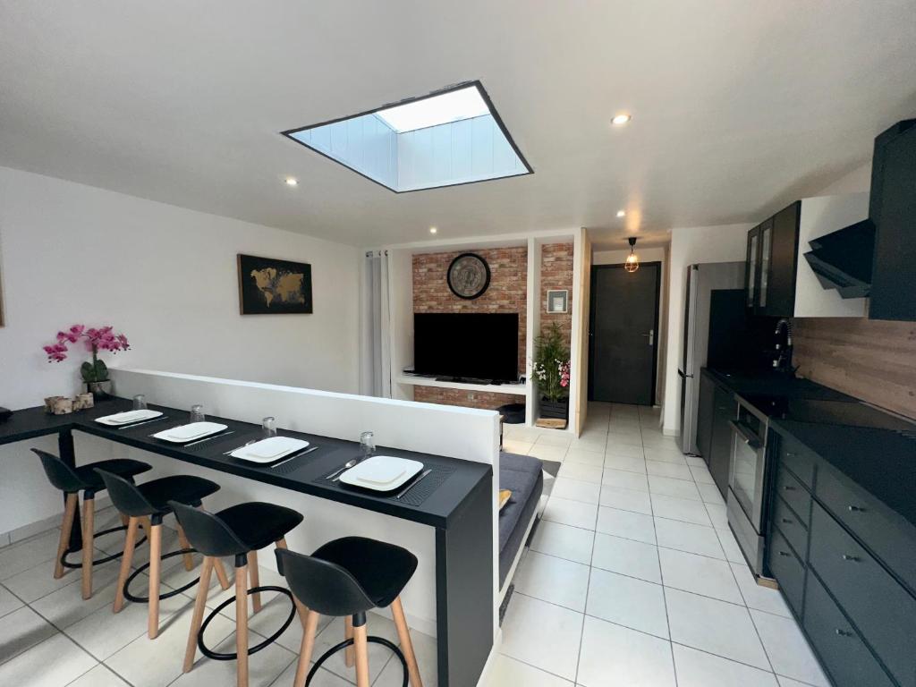 - une cuisine avec une table à manger et des tabourets dans l'établissement Appartement à 50m de la plage, à Saint-Hilaire-de-Riez