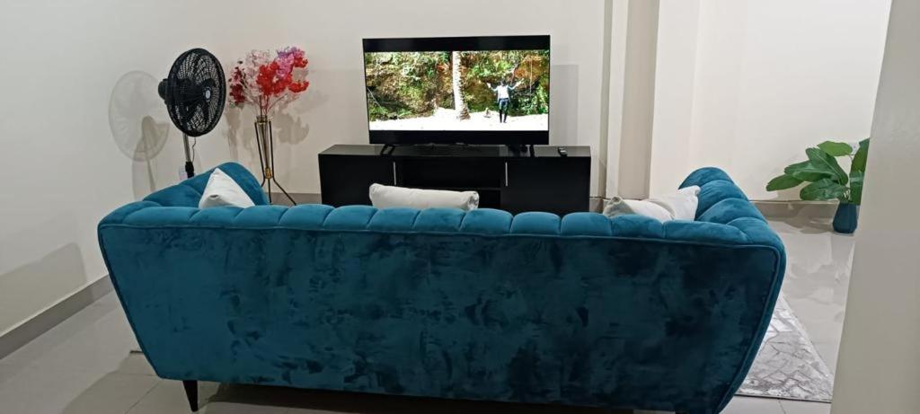 a blue couch in a living room with a tv at Khalisee homes 1 BDR apartment in Kilifi