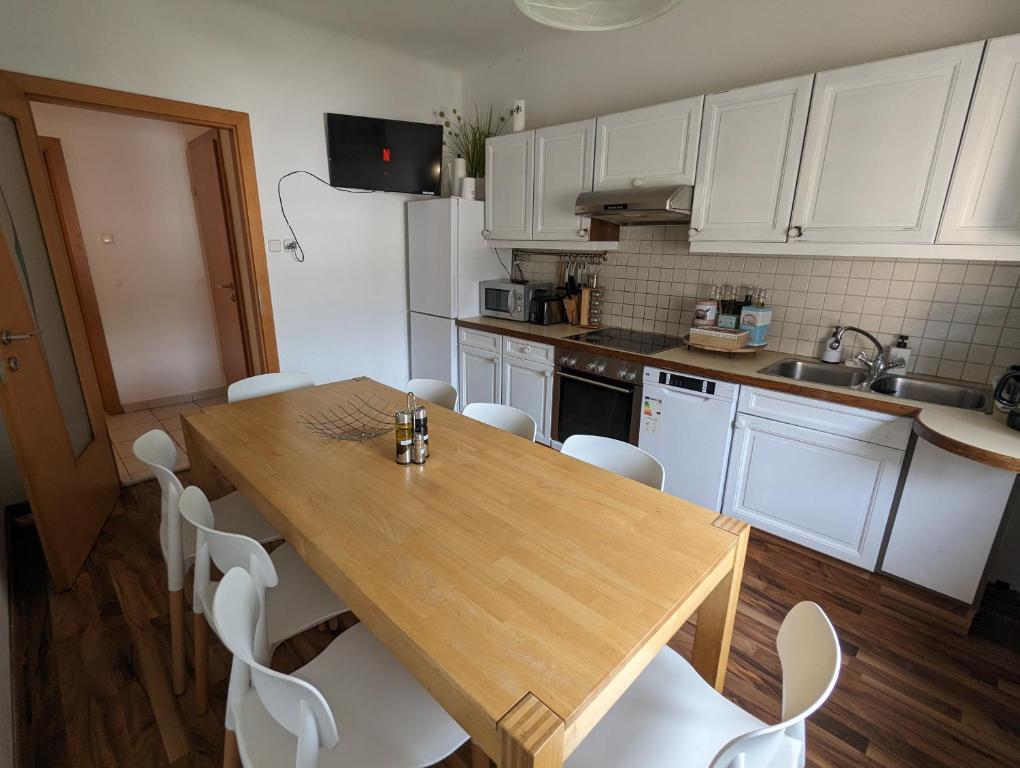 a kitchen with a wooden table and white cabinets at Perfect for Long Stays - 3BR Apt Across from Wels Convention Centre in Wels