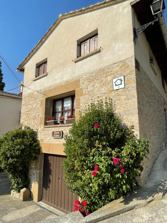 a brick building with a gate and flowers in front of it at Casa rural Amillano in Amillano