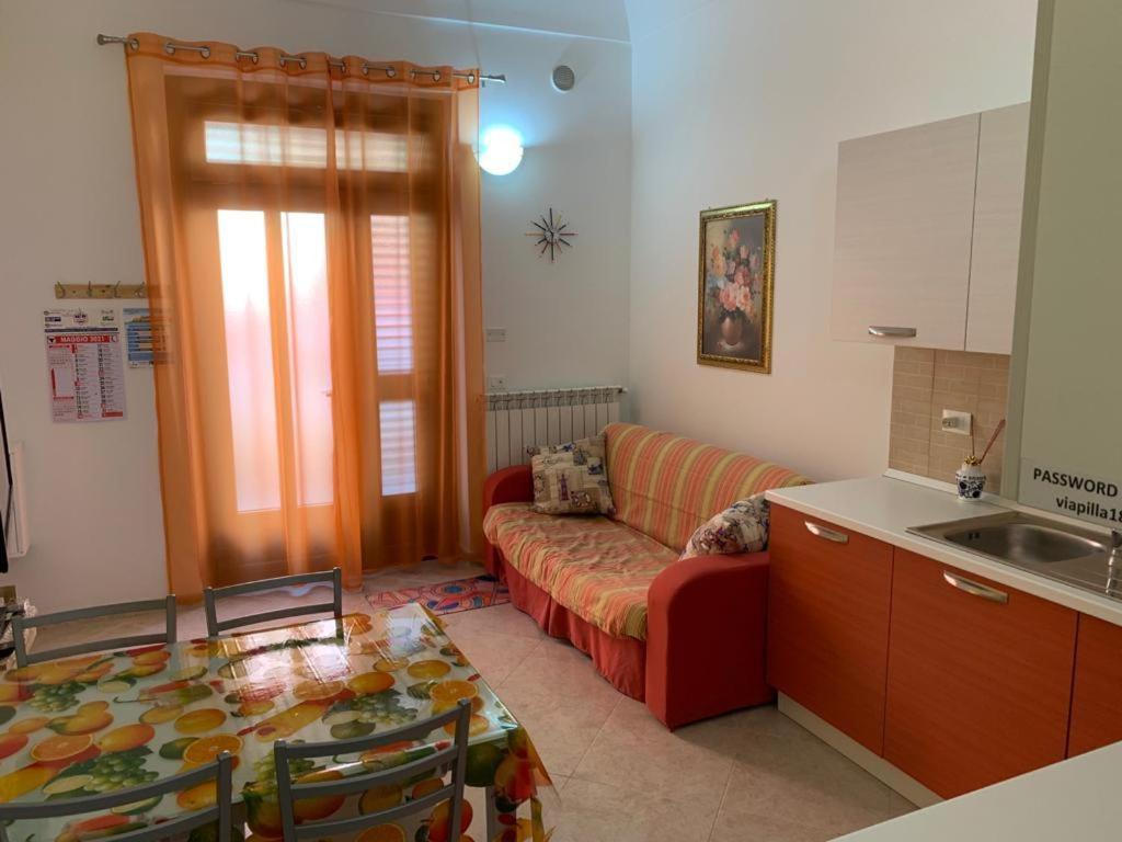 a living room with a red couch and a table at Casa sul porto imbarco Tremiti in Termoli