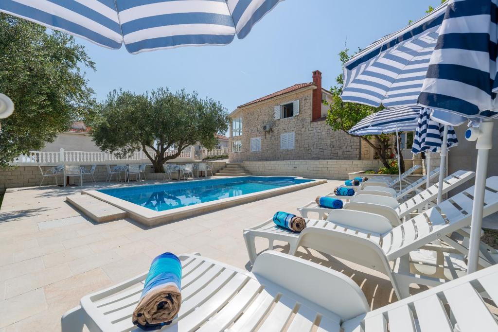 a group of lounge chairs and a swimming pool at Villa Tomasovic with pool in Podstrana in Podstrana