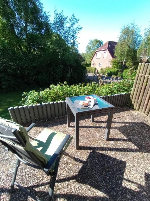 a patio with a table and a chair and a coffee table at Wattwurm in Wangerooge