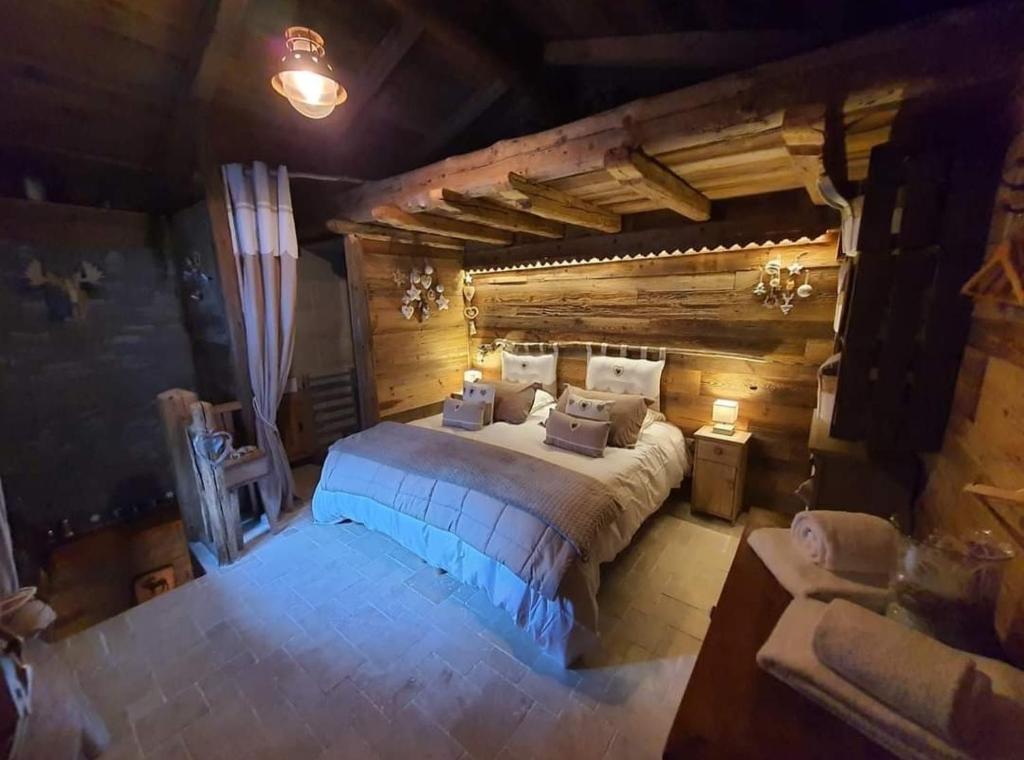 sypialnia z dużym łóżkiem w pokoju z drewnianymi ścianami w obiekcie Calme et sérénité 4 étoiles pour vos séjours VSD ou + w mieście Sixt